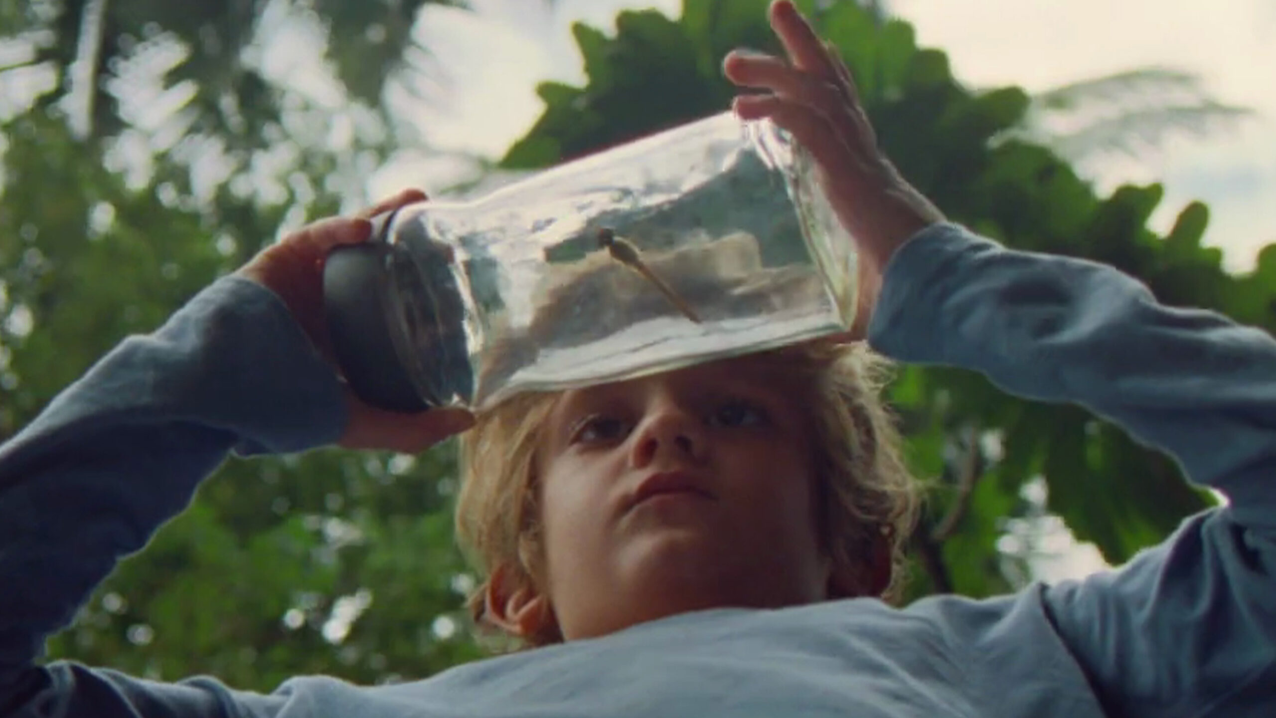 Nescafe Jar held by a young child with a bug in the jar